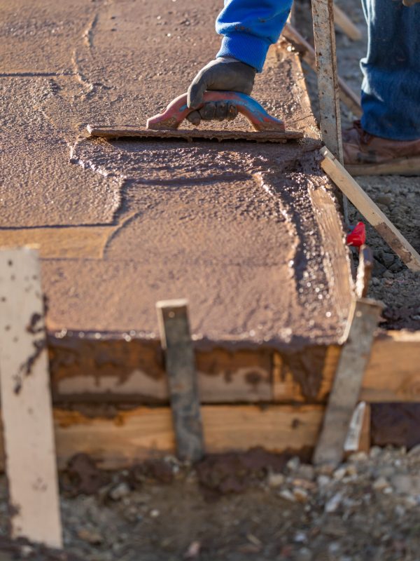 Construction Worker Smoothing Wet Cement With Trowel Tools